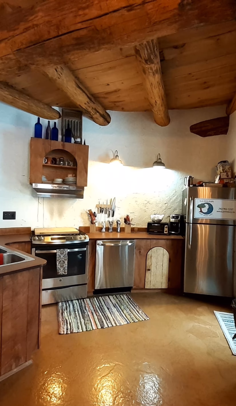 The full residential kitchen inside the Blue Moon Rising community center, with timber beams and an open cooking area
